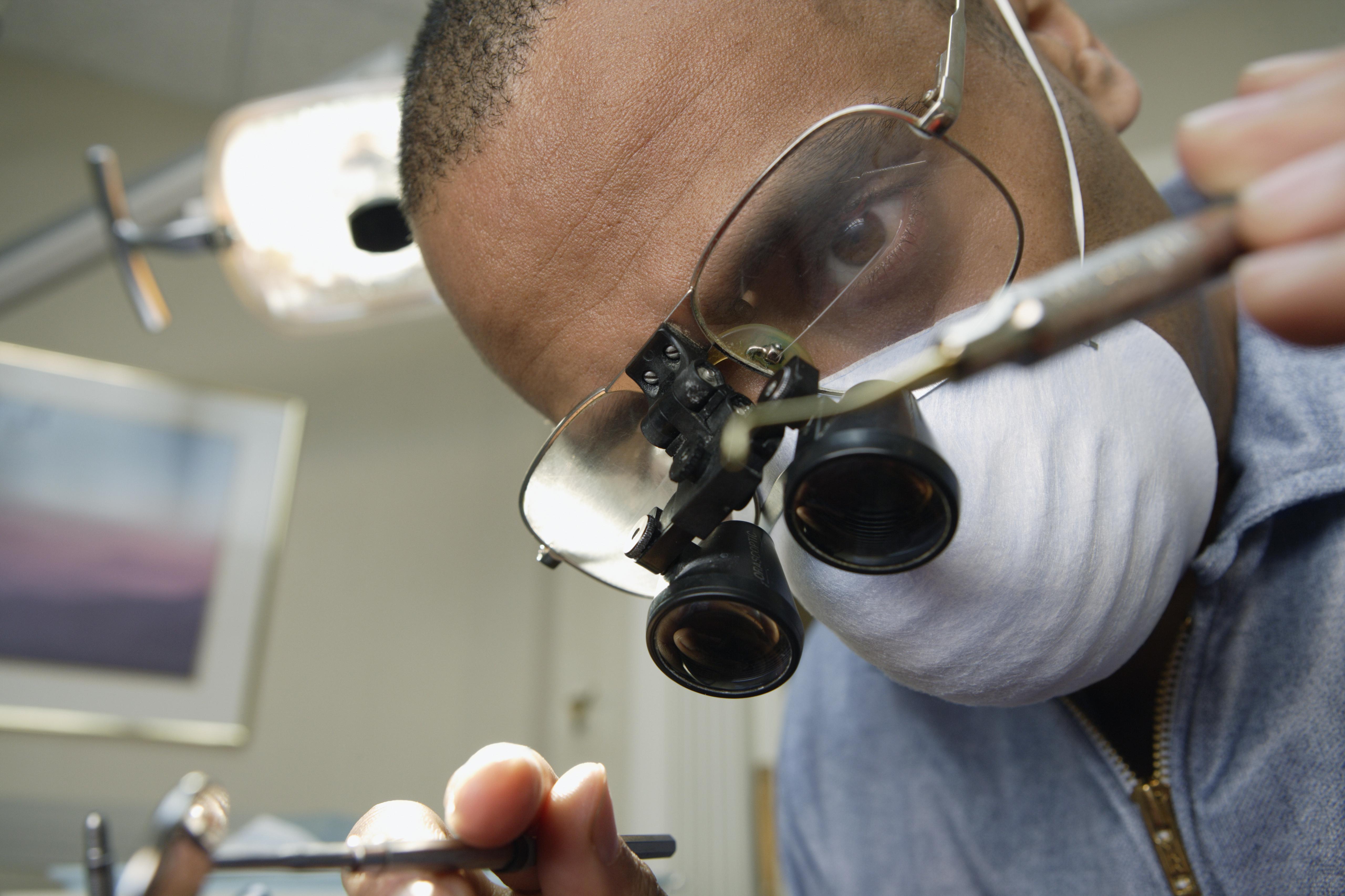 Indian male dentist performing exam