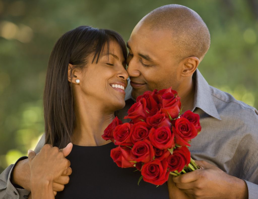 African American man giving flowers to wife