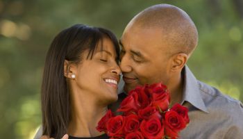 African American man giving flowers to wife