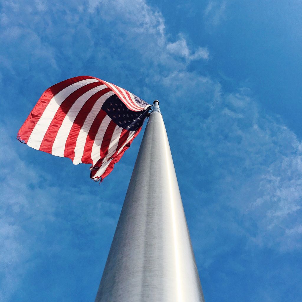 Low Angle View Of American Flag Against Blue Sky