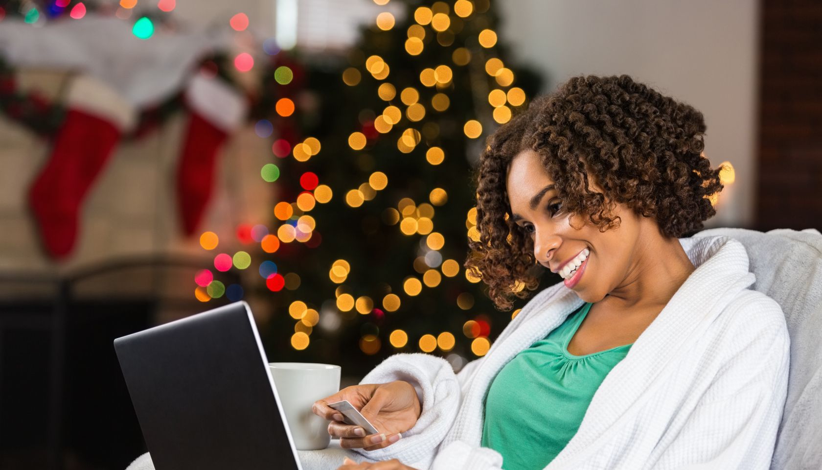 African American woman buying Christmas gifts online with credit card