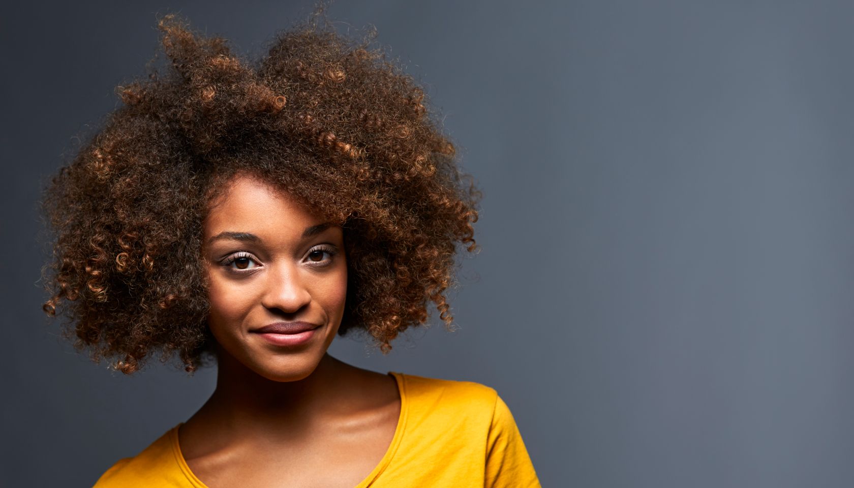 Portrait of smiling female against gray background