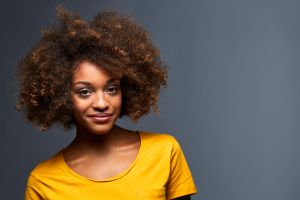 Portrait of smiling female against gray background