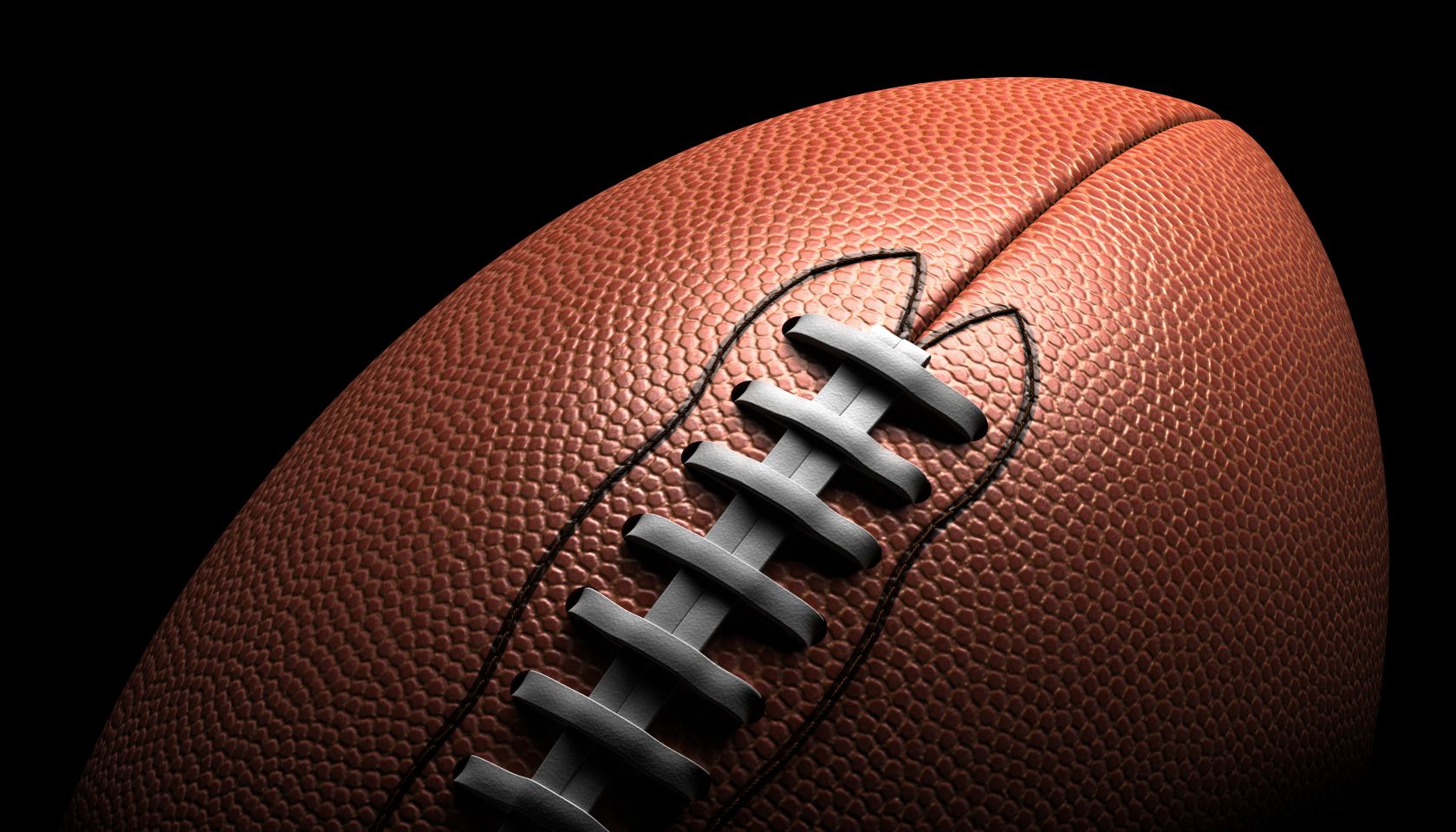American football on black background, close-up
