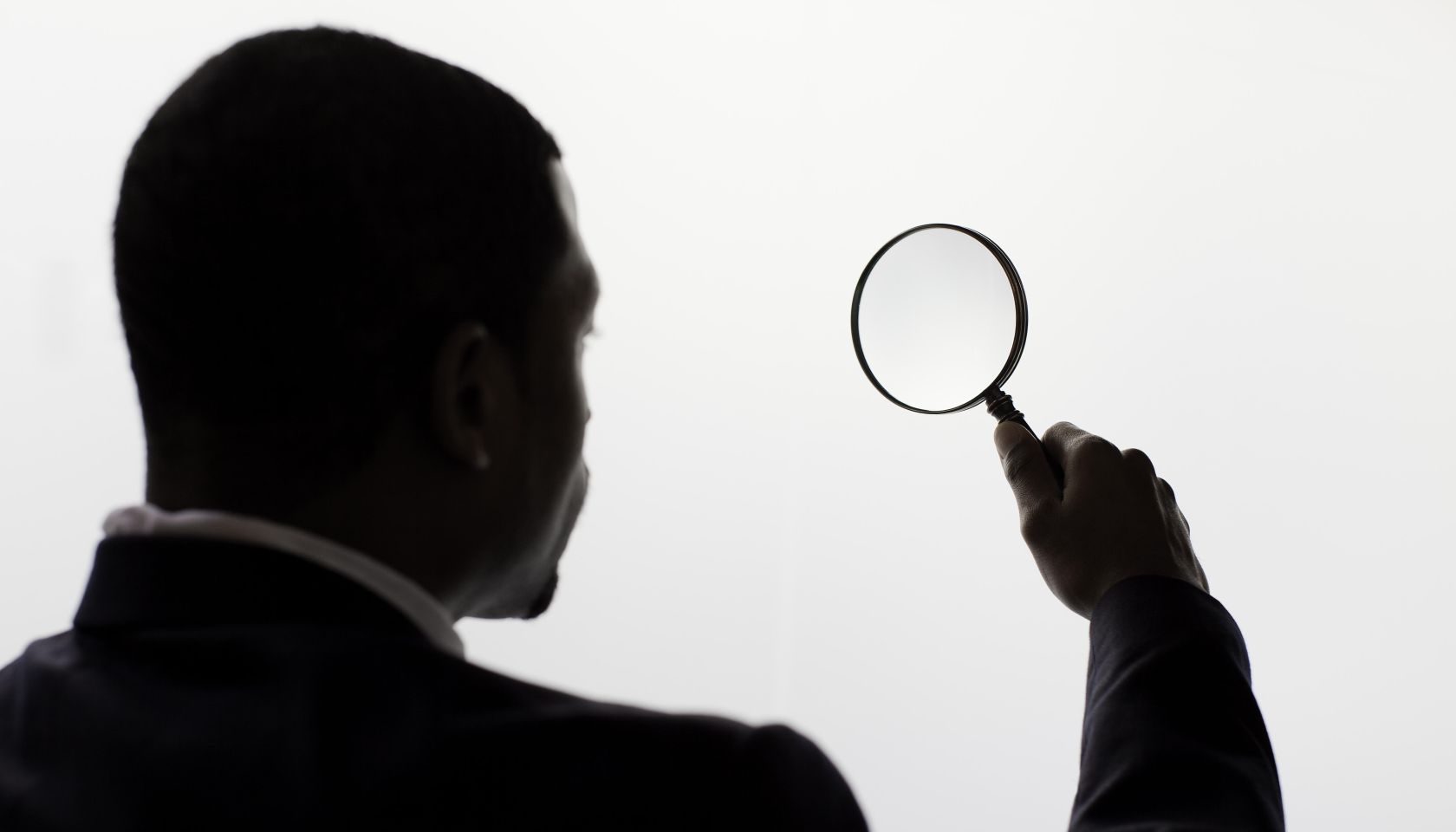 A man looking through a magnifiing glass.