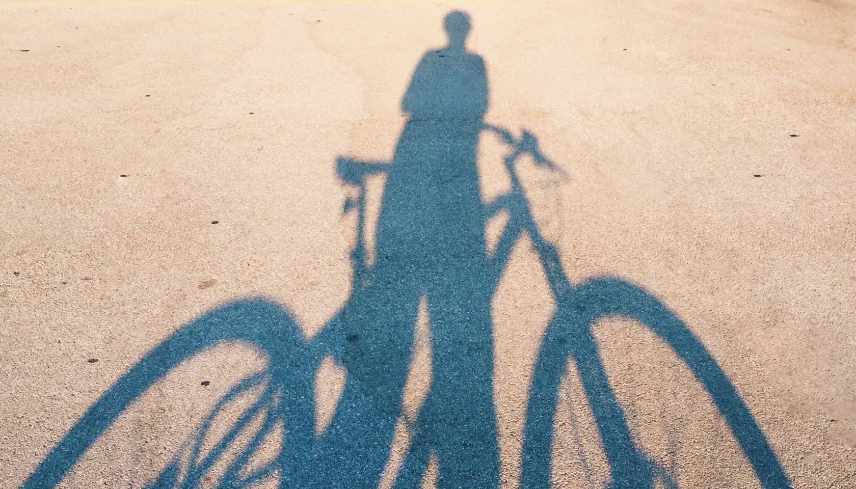Shadow Of Man With Bicycle On Road During Sunny Day