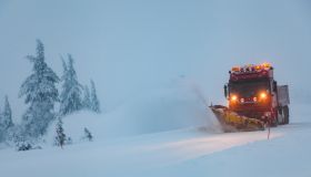 Snowblower grader clears snow covered country road