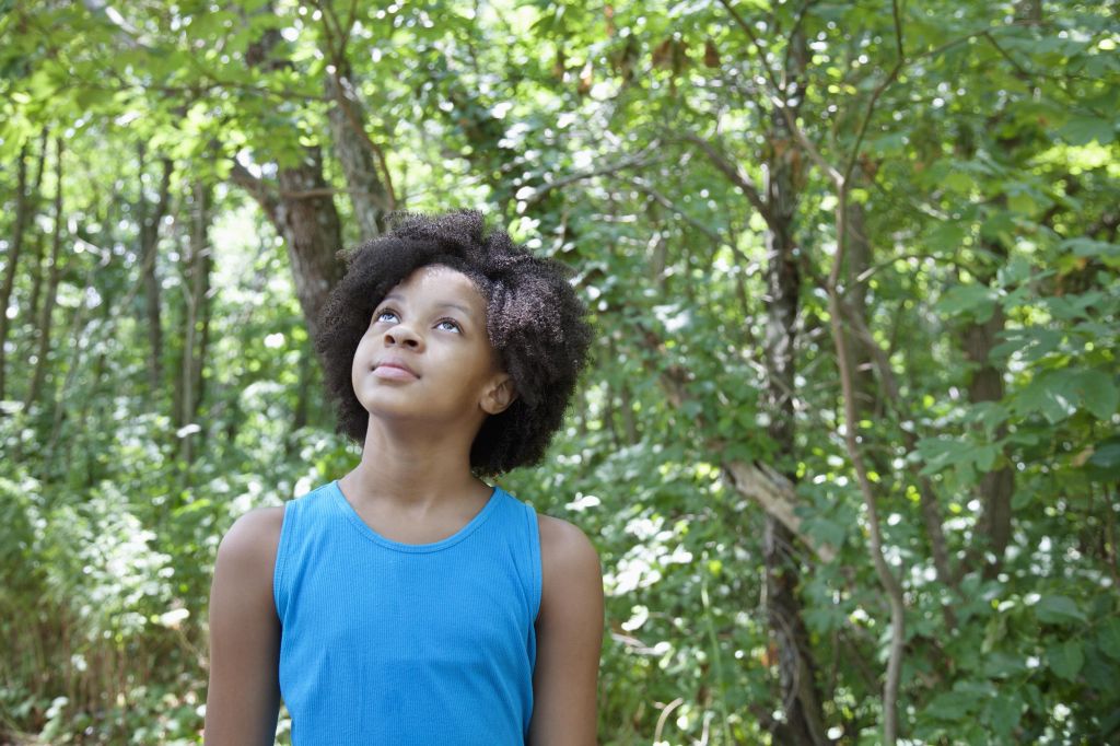 Young african american girl standing in a forest