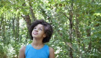 Young african american girl standing in a forest