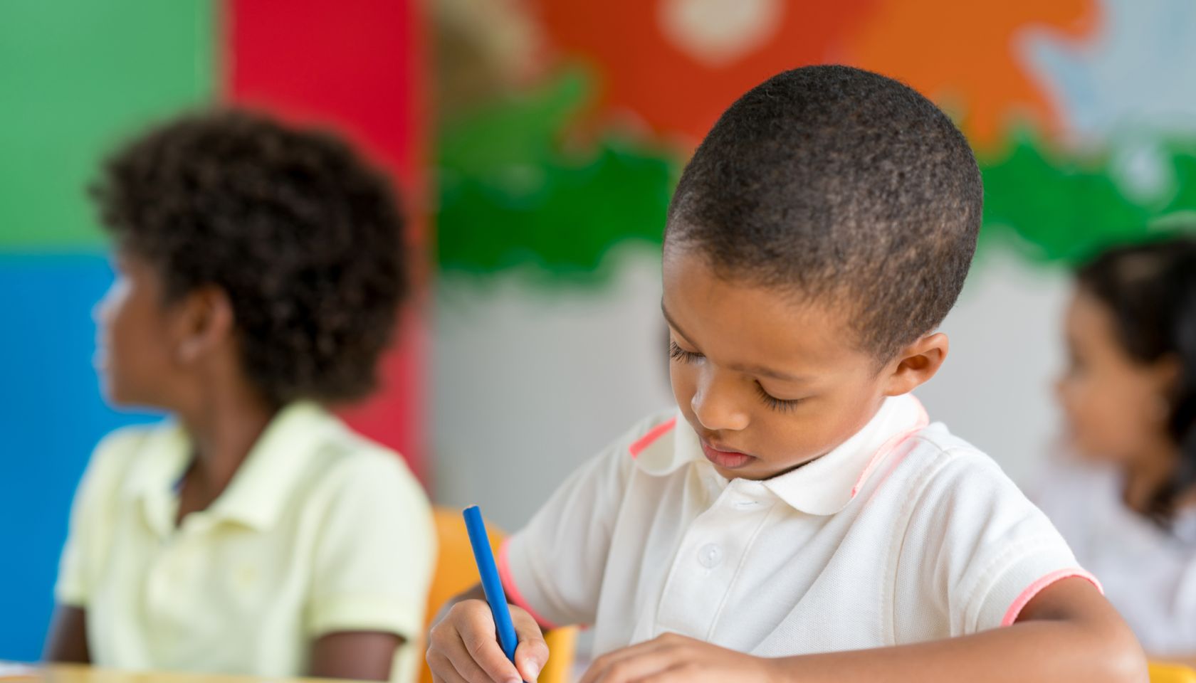 Portrait of a boy coloring at school